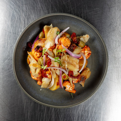 Salada de bacalhau com batata, couve-flor defumada, azeitona e ovo de codorniz