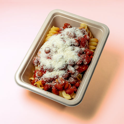 Bife de frango com molho de tomate, feijão e parmesão acompanhado com fusilli
