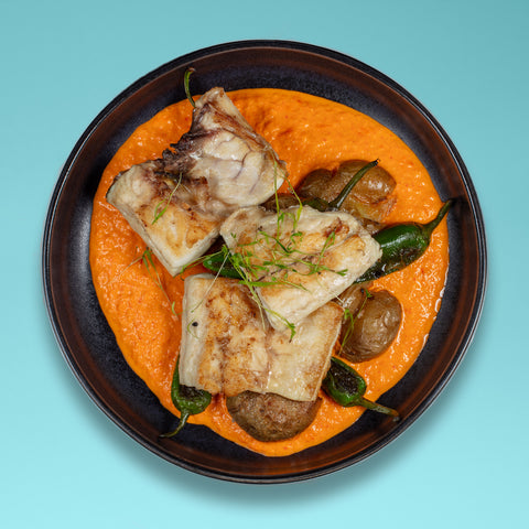 Robalo grelhado, batata a murro, pimentos padrón e romesco